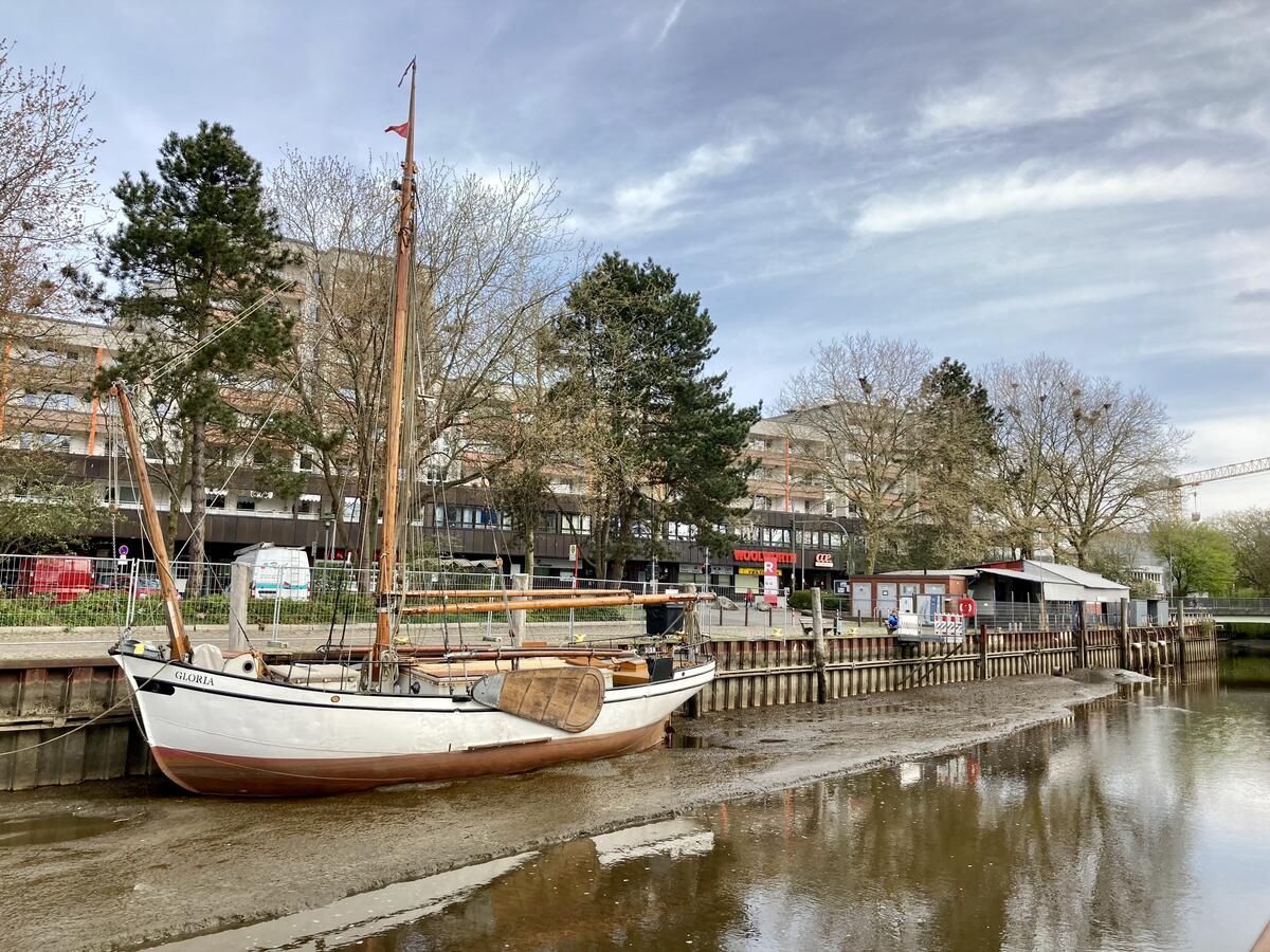 Bild vergrößern: Ein Segelschiff, der Ewer "Gloria", liegt vor der Spundwand des Nordufers im Elmshorner Hafen. Im Hintergrund steht das CCE.