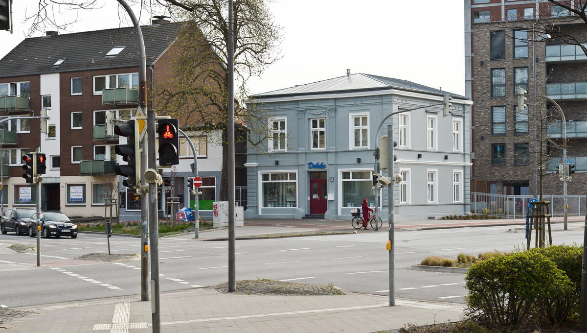 Bild vergrößern: Das Foto zeigt die Verkehrskreuzung Reichenstraße / Westerstraße / Vormstegen / Klostersande. Im Bildmittelpunkt steht das sanierte Stadthaus Vormstegen 43. Das grau gestrichene Haus hat historische Fenster und ein neues Dach erhalten.
